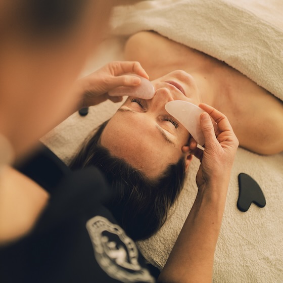 Cliente recevant un massage facialiste à Valence avec l'outil Gua Sha